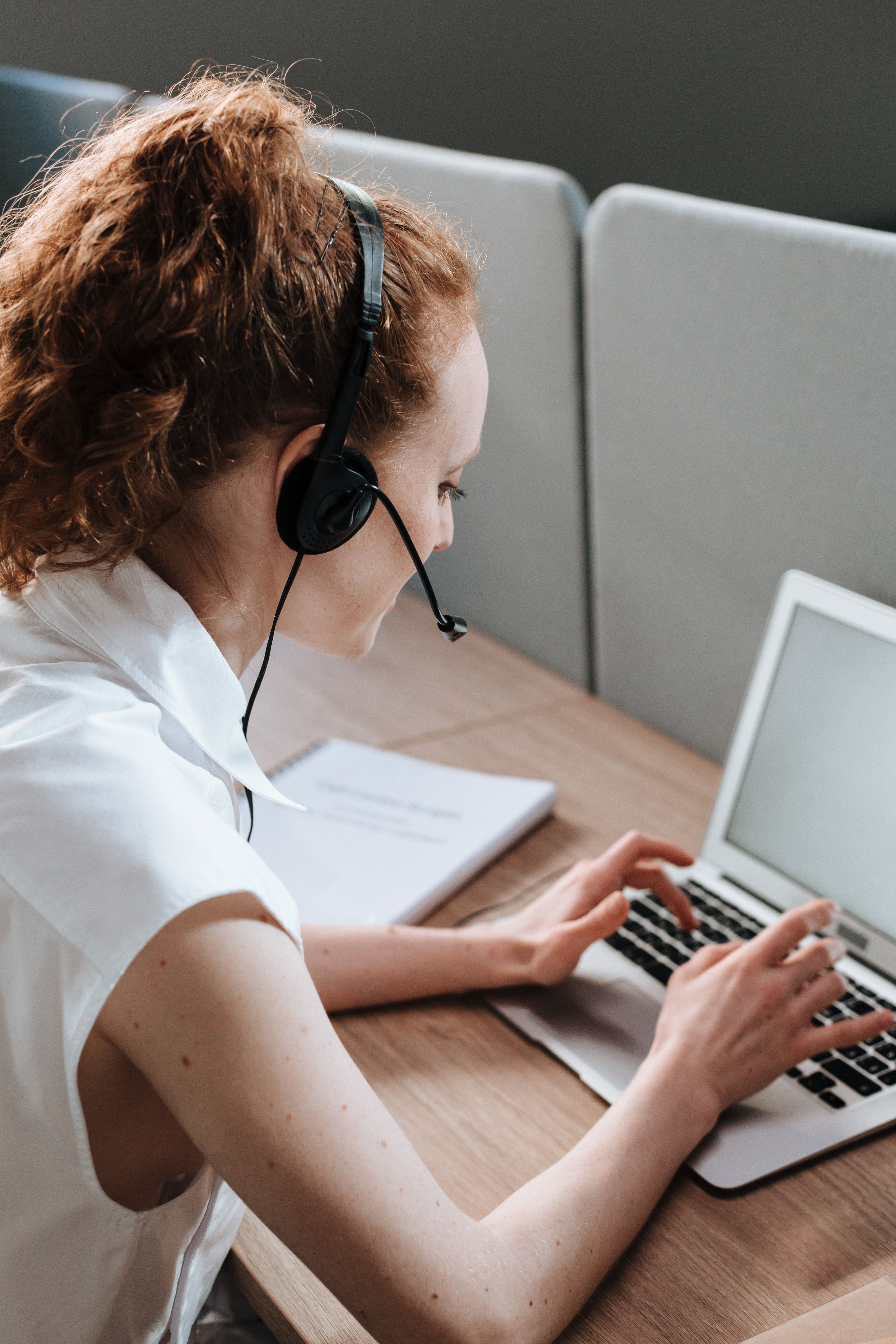 Une employée est au téléphone et écrit sur son ordinateur